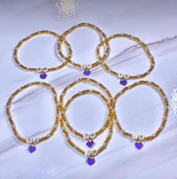 a set of bracelets with gold and purple beads